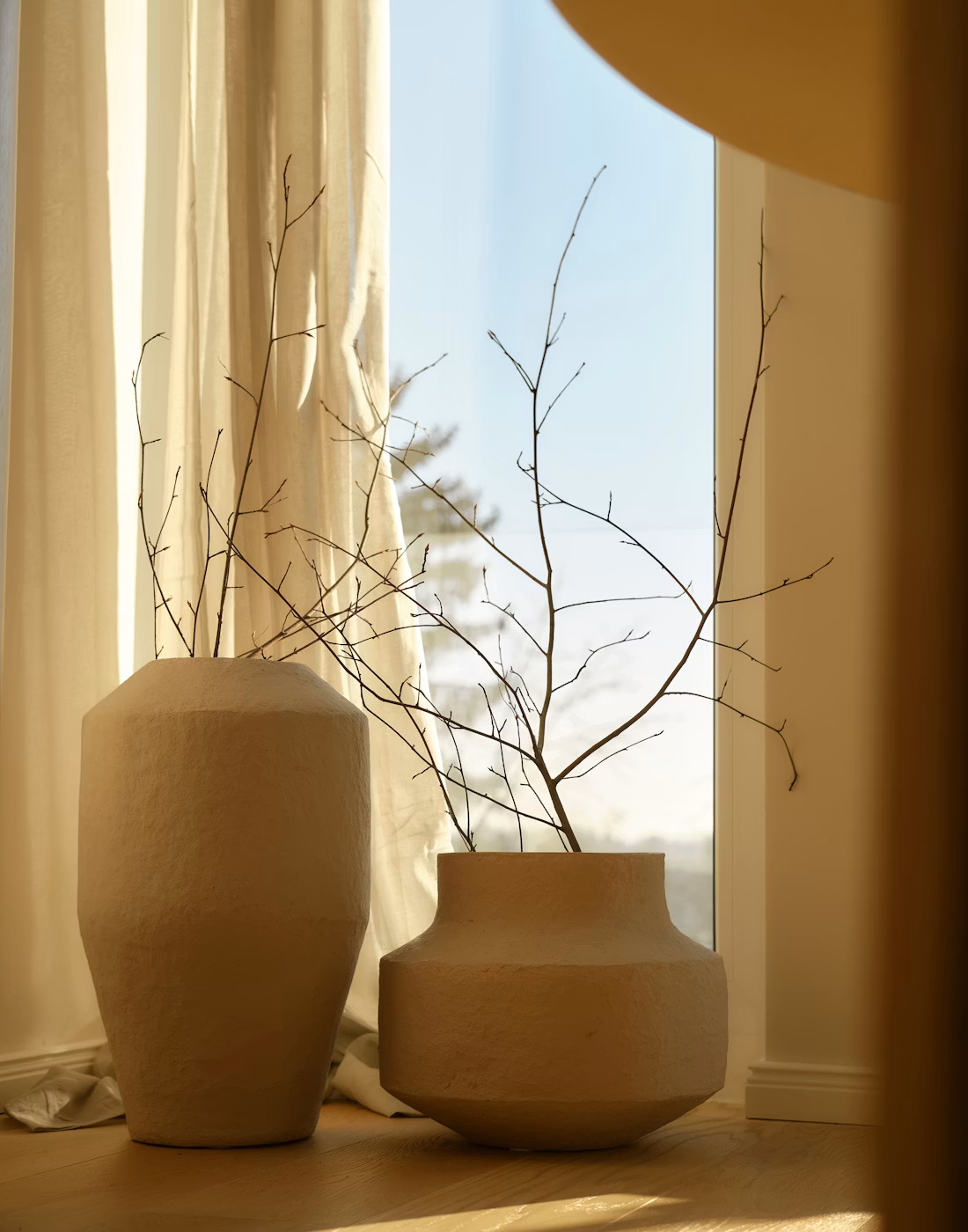 Textured ceramic vases in warm window light